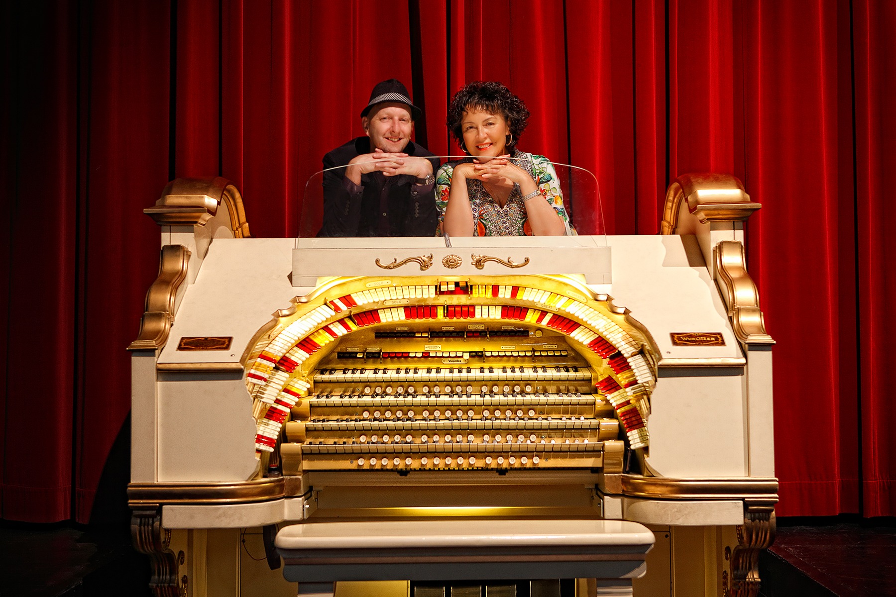 Ruby Page and Scott Harrison playfully posed behind the Wurlitzer console